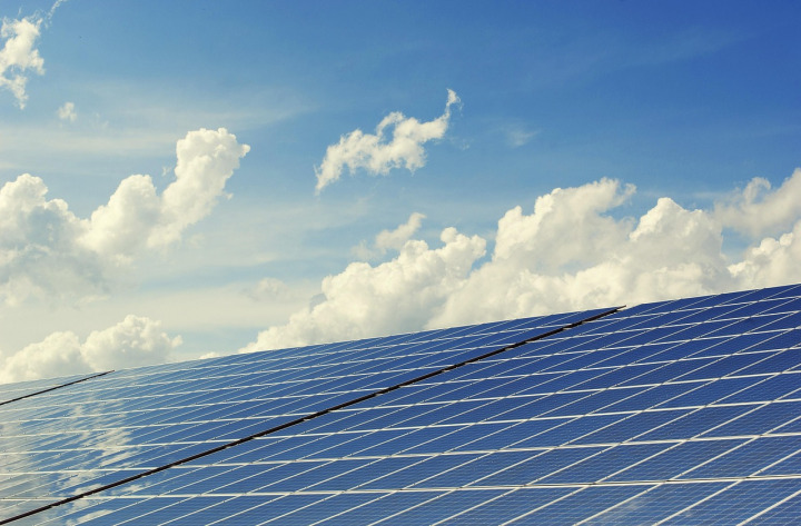 Modern solar PV panels installed on residential rooftop with blue sky background